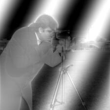 Cameraman photo with soft, rolling black and white diagonal bands
         overlaid on image, which is otherwise compressed towards middle gray.