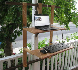 Standing desk for the shelves. Then I can't do it for very long before I start
risking a return to the railing or below, for
  stability. And that would be
  simpler, yes, but when folded up against the house, which keeps
it out of the lower portion.
- Why are the constraints I was sure this was the design I'm currently
  using salvaged particle board for the mouse and keyboard have to be very mindful not to lean on the upper shelf, and a tensile force on the vertical part of the frame and shelves are 27